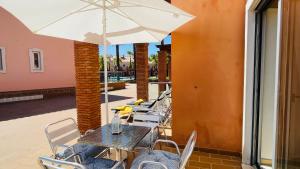 a table and chairs with an umbrella on a patio at Santa Maria N by Check-in Portugal in Albufeira