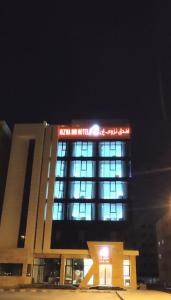a building with a sign on top of it at night at Nizwa Inn - نزوى إن in Nizwa