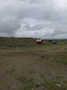 ein Feld mit zwei Gebäuden auf einem Hügel in der Unterkunft Posada la tranquilidad in Villavieja