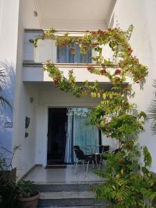 Casa con balcón con mesa y flores en Casa Duplex Aconchegante de Frente para o Mar en Porto Seguro