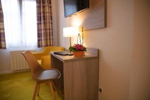 a room with a desk with a chair and a lamp at Hostellerie Saint Florent in Oberhaslach