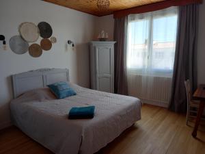 a bedroom with a bed and a large window at Les Crevettes in LʼÉpine