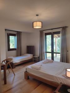 a bedroom with two beds and a large window at ALTANA in Torraca