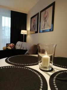 una vela sentada en una mesa en una sala de estar en Apartament71, en Płock