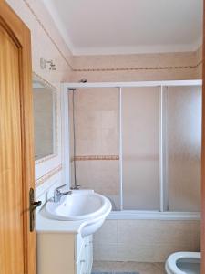 un baño con lavabo y ducha en Oliveira Beach House, en Longueira