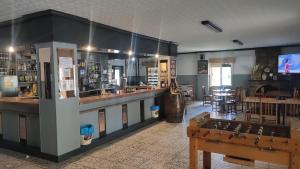 a large room with a bar and a restaurant at Hostal Restaurante Solaire in Castañar de Ibor