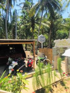 un groupe de motocycles garés sous un hangar dans l'établissement The Vagary Vibes, à Nusa Penida