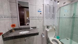 a bathroom with a toilet and a sink and a shower at Lar de Nanci e Beto in Arraial do Cabo +47 photos