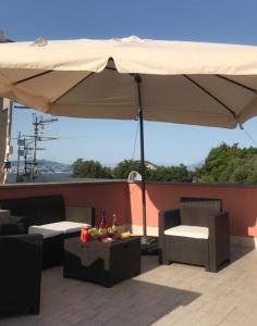 une terrasse avec un parasol, une table et des chaises dans l'établissement B&B La Lingua, à Procida