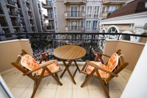 a wooden table and two chairs on a balcony at DPark Apartament in Sunny Beach