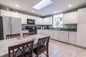 a kitchen with white cabinets and a table with chairs at Armory Quarters B in Harpers Ferry