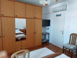 a bedroom with a large wooden cabinet and a bed at Room Slavica in Mali Lošinj