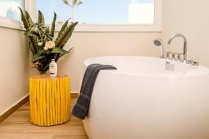 y baño con bañera y taburete amarillo. en Residence by Georgia Studios en Fira