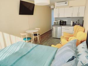 a room with a bed and a kitchen with a table at Studio SunSet in Pärnu