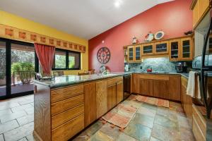 a kitchen with wooden cabinets and a red wall at Four Queens in Chapel in Sedona