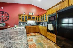a kitchen with wooden cabinets and a black refrigerator at Four Queens in Chapel in Sedona +35 photos