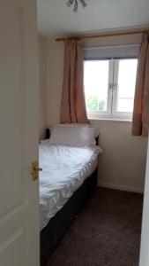 a small bedroom with a bed with a window at Beeston House in Thornton