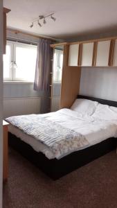a bedroom with a large bed with white sheets and a window at Beeston House in Thornton