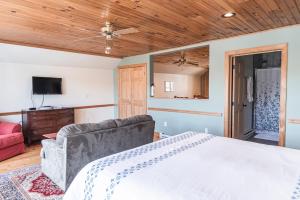 1 dormitorio con 1 cama grande y 1 sofá en The Loft at the Barn en Bolivar