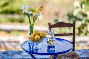 a blue table with a vase of flowers and a bowl of fruit at Villa Itilo in Neo Itilo +56 photos