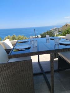 a table with glasses and napkins on top of a patio at Logement 45 m2 vue mer in San-Martino-di-Lota