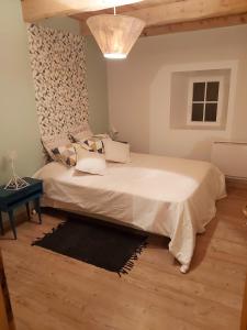 Un dormitorio con una gran cama blanca y una mesa en Maison de 2 chambres a Lanarce a 800 m de la plage avec sauna et jardin clos, en Lanarce