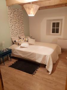 a bedroom with a large white bed and a table at Maison charmante à Lanarce avec vue sur la montagne, jacuzzi. in Lanarce +29 photos