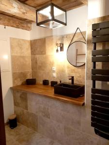 La salle de bains est pourvue d'un lavabo noir et d'un miroir. dans l'établissement Maison de 2 chambres a Lanarce a 800 m de la plage avec sauna et jardin clos, à Lanarce