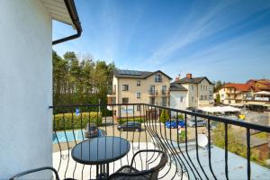 a balcony with a table and chairs and a pool at Leokadia przy plaży kwatery prywatne in Mielno