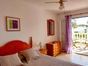 a bedroom with a bed and a window with a patio at Villa Limón in Cala Blanca +24 photos