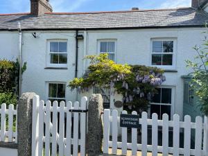 a white picket fence in front of a house at Feock beautiful sunny cottage in Truro