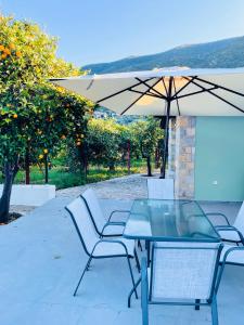 een tafel en stoelen met een parasol op een patio bij Citrus garden in Oud Epidauros