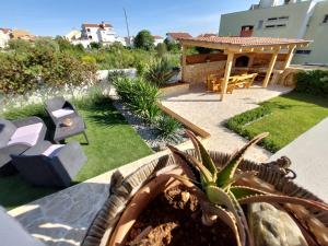 un jardín con una mesa y un banco y una casa en Apartment Green Oasis, en Zadar