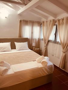 um quarto com 2 camas e uma janela com cortinas em Citrus garden em Ancient Epidavros