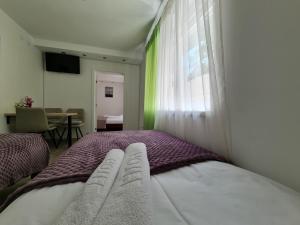 a bedroom with a bed and a window and a table at "Astor16" Apartments in Niš