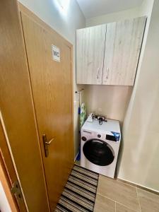 a laundry room with a washer and dryer next to a door at Sunny in Varna City +17 photos
