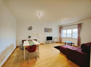 a living room with a couch and a table at Sunny Home Lisboa Expo, free parking in Lisbon