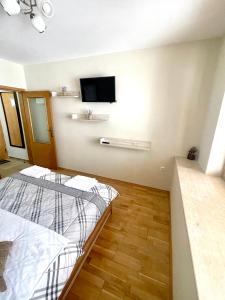 a bedroom with a bed and a flat screen tv at Sunny in Varna City