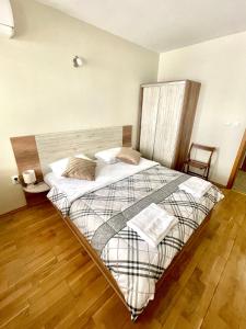 Cama grande en habitación con suelo de madera en Sunny en Varna