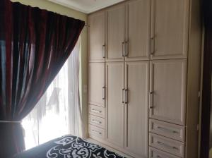 um quarto com armários brancos e uma janela em Διαμέρισμα για 4 με θέα θάλασσα σε ήσυχη γειτονιά em Chalkida