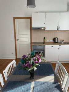 a kitchen with a table with a vase of flowers on it at Spacious Ausekla apartment in Liepāja
