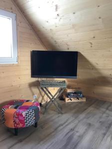 telewizor z płaskim ekranem w drewnianym pokoju w obiekcie MAZUR 35 w mieście Szyldak
