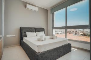 Un dormitorio con una cama y una ventana grande. en Stay in Style in Modern 3 Bedroom Villas Near Nissi Beach & Square, en Ayia Napa 42 fotos más