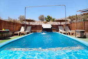 una piscina con sedie e tavolo e una piscina di Esencia Eco-rústico a El Charco