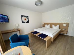 コッヘムにあるHaus Erholungのホテルルーム(ベッド1台、青い椅子付)