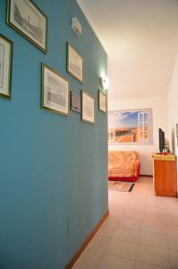 una stanza con una parete blu con delle immagini di ALLA POSTA cozy apartment close to Venice a Noale