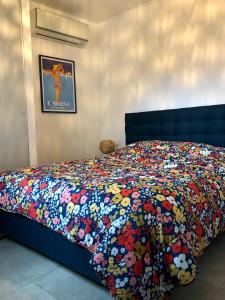 a bed with a colorful comforter on top of it at Superbe appartement sur le port, jacuzzi, piscine in Porto-Vecchio