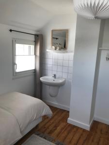 ein Bad mit einem Bett, einem Waschbecken und einem Spiegel in der Unterkunft Ferienhaus Eifeldömchen in Bad Münstereifel