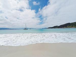 a sail boat in the water on a beach at Hospedaje O Canizo in Hio