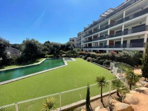 a large lawn in front of a apartment building at Superbe appartement sur le port, jacuzzi, piscine in Porto-Vecchio